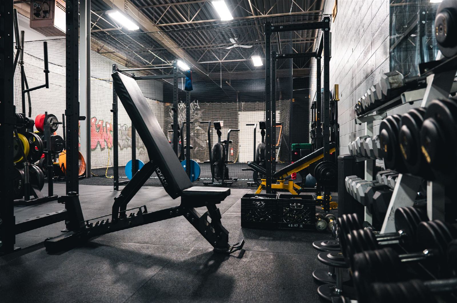 Inside the Raw Iron Performance training facility: squat racks, benches, and a wall of dumbbells